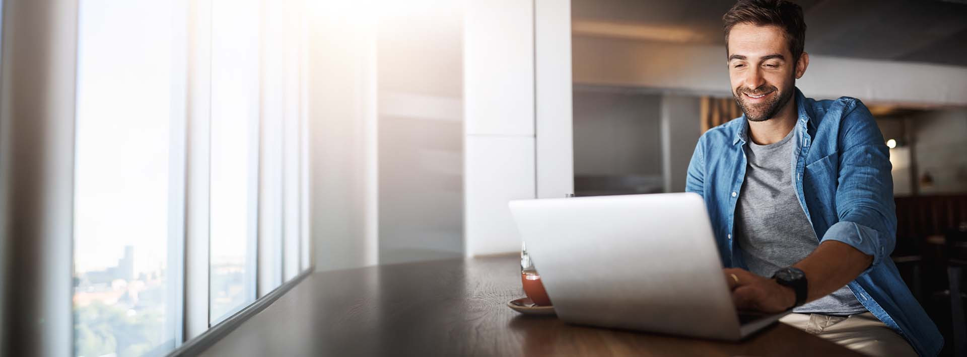 Mężczyzna korzystający z laptopa przy zarządzaniu kontem bankowym online