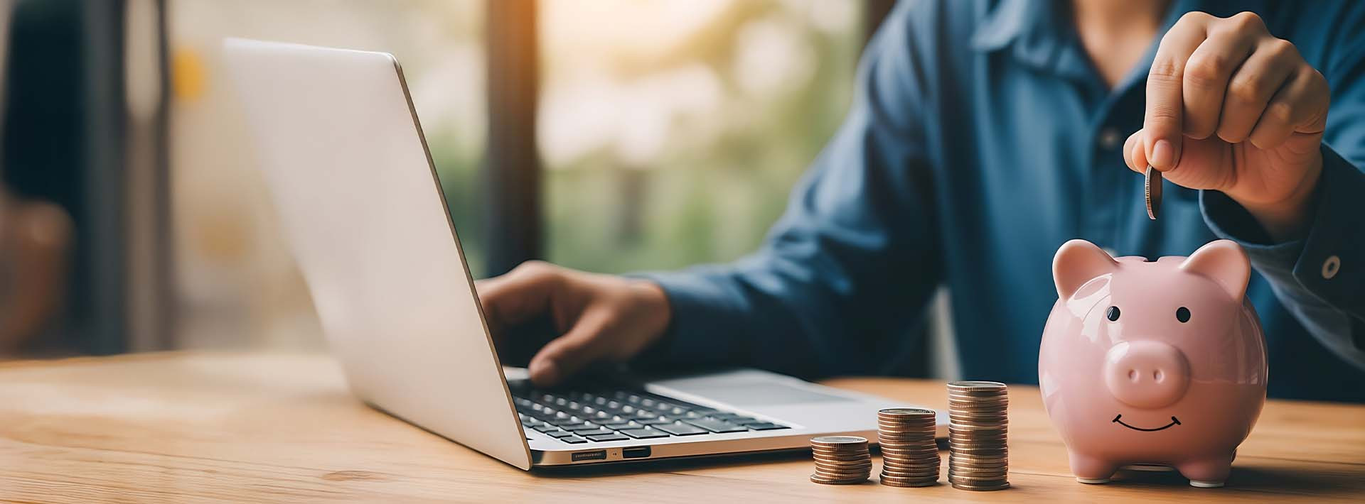 Skarbonka w kształcie świnki i ręka owkładająca do niej monetę