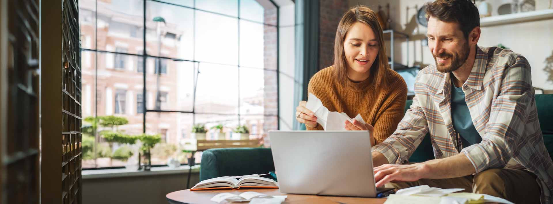 Para analizująca wydatki przy laptopie