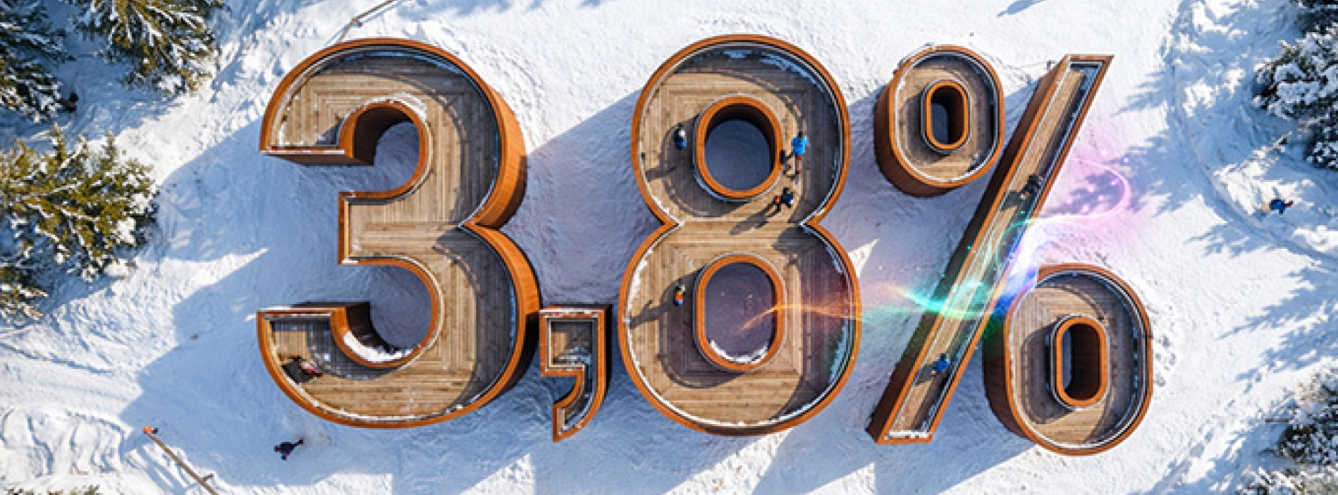 Widok z lotu ptaka na leśną polanę w śniegu, na niej budynek w kształcie liczby 3,8% symbolizująca oprocentowanie lokaty