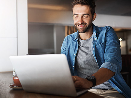 Mężczyzna korzystający z laptopa przy zarządzaniu kontem bankowym online