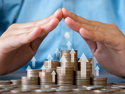 Dłonie tworzą kształt ochronny nad rosnącymi stosami monet; strzałki w górę wskazują wzrost wartości oszczędności lub inwestycji