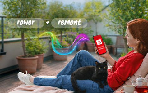 Kobieta siedząca na balkonie z kotem na kolanach i przeglądająca aplikację Santander Consumer Bank na telefonie. Na górze baneru napis rower+remont.