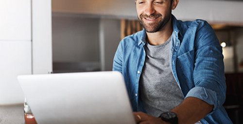 Mężczyzna korzystający z laptopa przy zarządzaniu kontem bankowym online