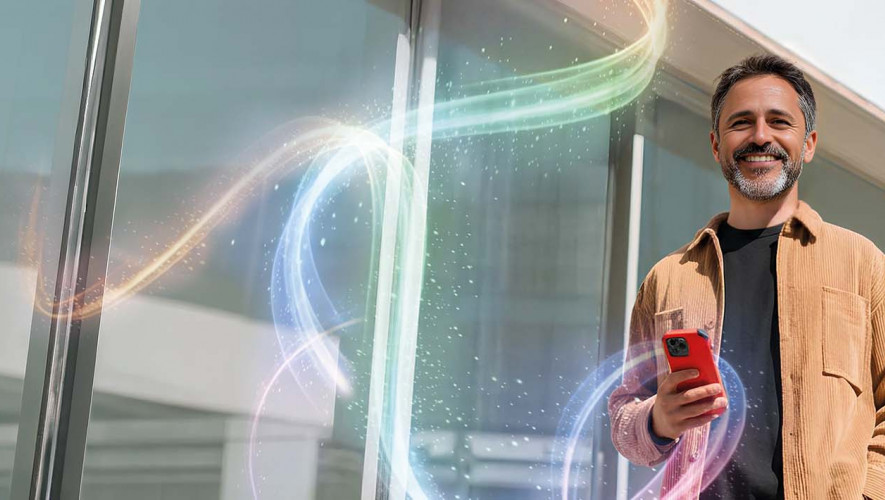 Mężczyzna z telefonem w dłoni, ekran smartfona z aplikacją bankową. Napis: Otwórz się na wygodę z aplikacją.